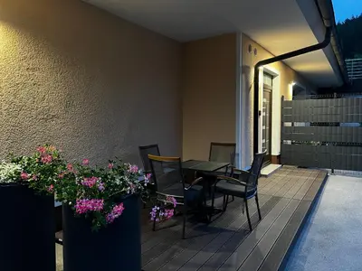 a patio with a table and chairs and flowers at Dih narave in Stahovica