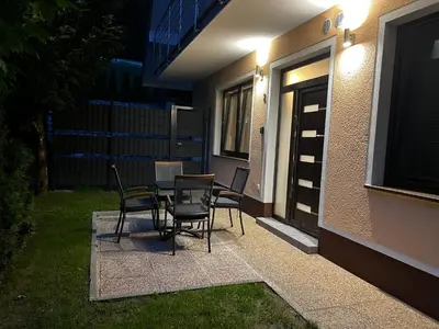 a patio with chairs and a table in front of a building at Dih narave in Stahovica