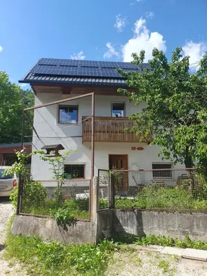 a house with solar panels on top of it at ALPINE VILLAGE APARTMENT with a private terrace, garden, and parking - at a walking distance from LAKE BLED in Bohinjska Bela