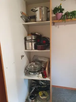 a kitchen pantry with dishes and pots and pans at ALPINE VILLAGE APARTMENT with a private terrace, garden, and parking - at a walking distance from LAKE BLED in Bohinjska Bela