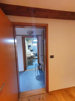 a hallway with a door leading to a dining room at ALPINE VILLAGE APARTMENT with a private terrace, garden, and parking - at a walking distance from LAKE BLED in Bohinjska Bela