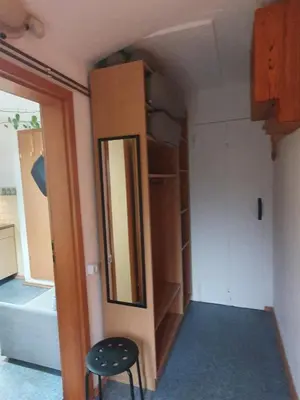 a closet with a mirror and a stool in a room at ALPINE VILLAGE APARTMENT with a private terrace, garden, and parking - at a walking distance from LAKE BLED in Bohinjska Bela
