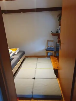 a small room with a bed and a table at ALPINE VILLAGE APARTMENT with a private terrace, garden, and parking - at a walking distance from LAKE BLED in Bohinjska Bela