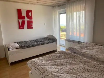 a bedroom with two beds and a window with the words loge at Green Hill in Jesenice na Dolenjskem