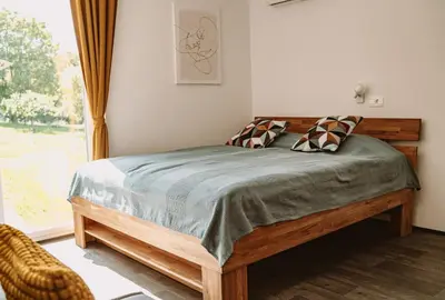 a bedroom with a wooden bed in a room with a window at Green Hill in Jesenice na Dolenjskem
