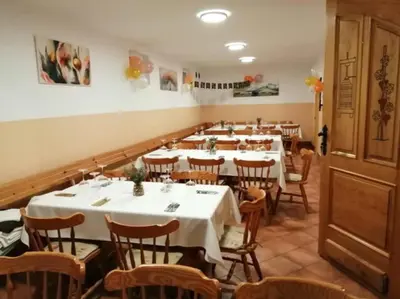 a dining room with white tables and wooden chairs at Green Hill in Jesenice na Dolenjskem