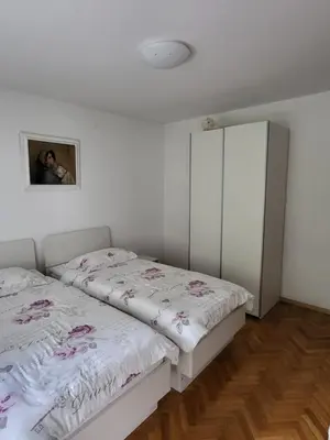 a bedroom with two beds and a cabinet at Apartma Magdalena in Kobarid
