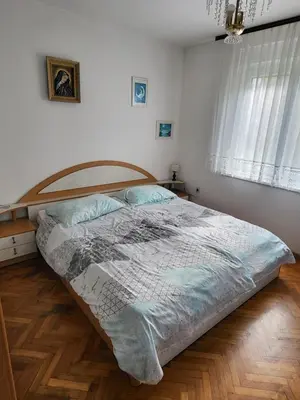 a large bed in a bedroom with a wooden floor at Apartma Magdalena in Kobarid