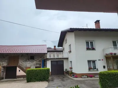 a white house with a garage and a building at Apartma Magdalena in Kobarid