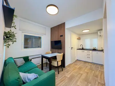 a living room with a green couch and a table at Hiška pod hrastom, G110 Podčetrtek, Aqualuna, Olimia in Podčetrtek