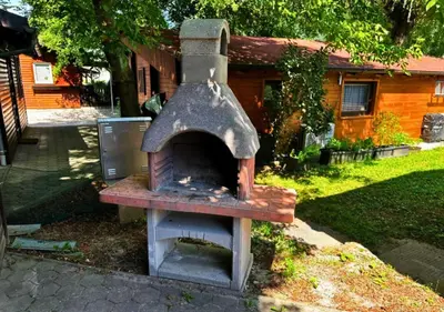 an outdoor oven in front of a house at Hiška pod hrastom, G110 Podčetrtek, Aqualuna, Olimia in Podčetrtek