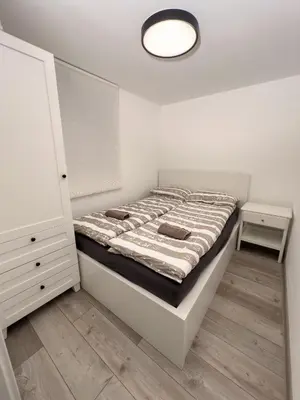 a white bedroom with a bed and a lamp at Hiška pod hrastom, G110 Podčetrtek, Aqualuna, Olimia in Podčetrtek