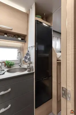 a kitchen with a black refrigerator and a sink at Camper GiottiLine Siena 385 in Šenčur