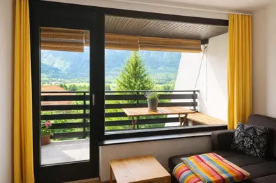 a living room with a couch and a large window at Apartma Lina in Bovec