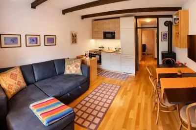 a living room with a couch and a table and a kitchen at Apartma Lina in Bovec