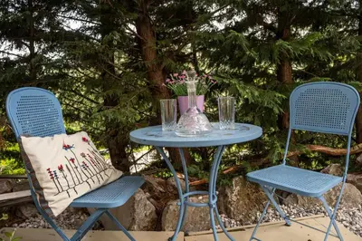 two chairs and a table with a vase on it at mobile house on a herbs farm in Ajdovščina