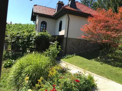 a small house with a garden with flowers at Wine & Nature & Tour in Ptuj
