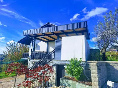a white building with a balcony on top of it at Studio Vista apartment in Leskovec pri Krškem