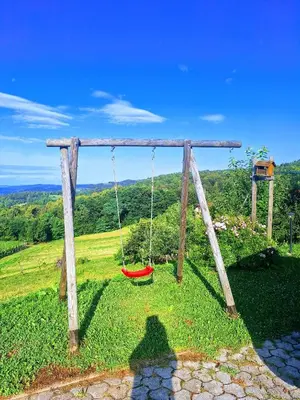a swing seat in a grassy field with a view at Studio Vista apartment in Leskovec pri Krškem