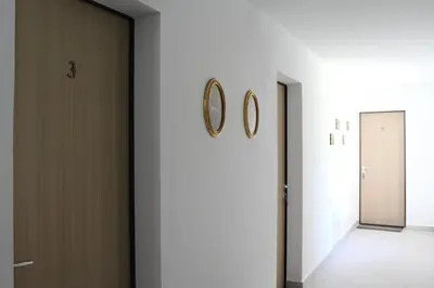 a hallway with two doors and two clocks on the wall at Grad Kojsko in Kojsko