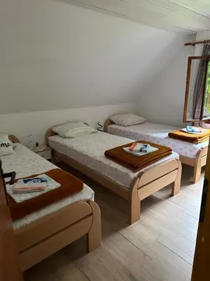 a room with three beds and two ottomans at Planinska koča na Kopitniku in Dol pri Hrastniku