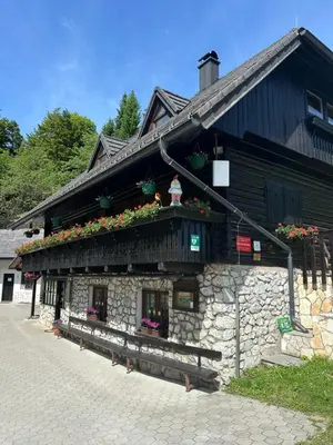 a building with flowers on the side of it at Planinska koča na Kopitniku in Dol pri Hrastniku