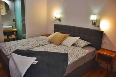 a bedroom with a bed with a gray headboard and pillows at Hiša Plesnik in Solčava