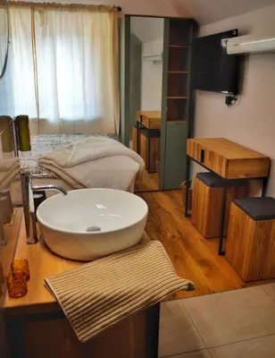 a bathroom with a bowl sink on a wooden counter at Hiša Plesnik in Solčava