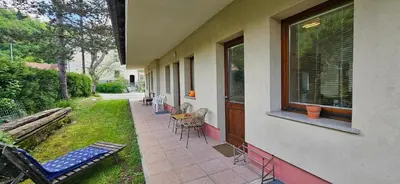 a porch of a house with chairs and a bench at Apartments Dvor by the Krka river in Rove