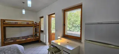 a room with a bedroom with bunk beds and a desk at Apartments Dvor by the Krka river in Rove