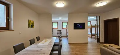 a dining room with a long wooden table and chairs at Apartments Dvor by the Krka river in Rove