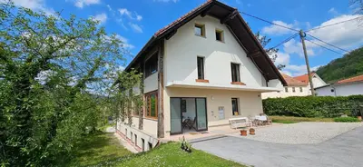 a white house with a black roof at Apartments Dvor by the Krka river in Rove