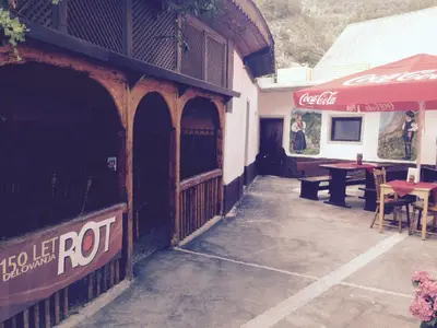a building with a restaurant with a red umbrella at B&B Rot in Bohinjska Bela