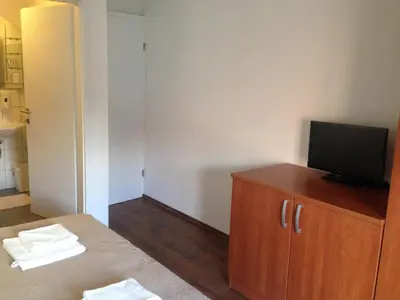 a room with a bed and a television on a cabinet at B&B Rot in Bohinjska Bela