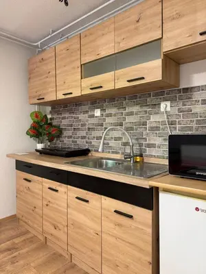 a kitchen with wooden cabinets and a sink at Piece of Heaven in Zgornje Gorje