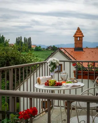 a table with a plate of fruit on a balcony at Dvorec Jeruzalem in Ivanjkovci