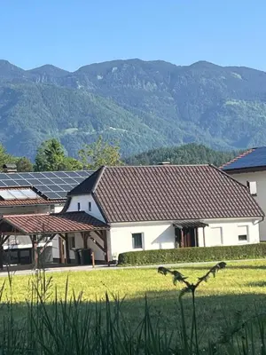 a row of houses with solar panels in a field at Apartma GoDeTi in Rečica ob Savinji