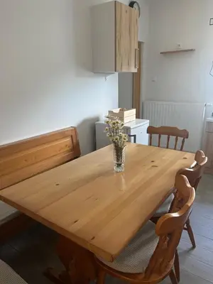 a dining room table with a vase of flowers on it at Apartma GoDeTi in Rečica ob Savinji