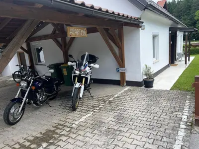 two motorcycles parked in a garage next to a house at Apartma GoDeTi in Rečica ob Savinji
