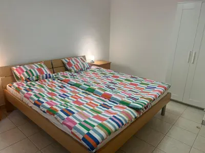 a bed with a colorful comforter in a bedroom at Apartma GoDeTi in Rečica ob Savinji