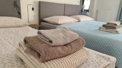 two beds with towels stacked on top of each other at Brne Family House in Postojna