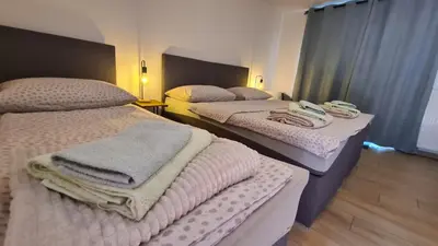 two beds in a hotel room with towels on them at Brne Family House in Postojna