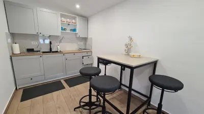 a kitchen with a table and two stools at Brne Family House in Postojna