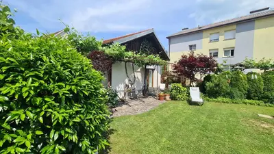 a garden with a house and a yard with bushes at Brne Family House in Postojna