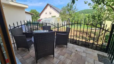 a patio with a table and chairs and a fence at Brne Family House in Postojna
