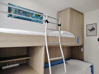 a bunk bed with a ladder in a small room at Vivere in Slovenia in Plavje