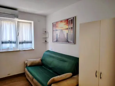 a living room with a green couch and two windows at Vivere in Slovenia in Plavje