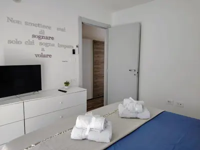 a bedroom with towels on a bed with a tv at Vivere in Slovenia in Plavje