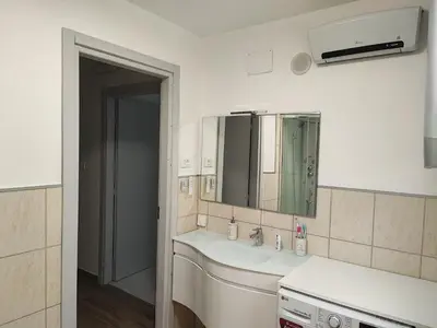 a white bathroom with a sink and a mirror at Vivere in Slovenia in Plavje