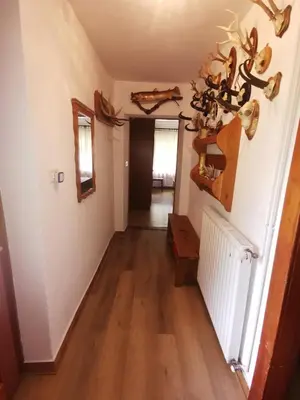 a hallway with white walls and wood floors and a hallway with a hallway at Idina domačija in Trenta